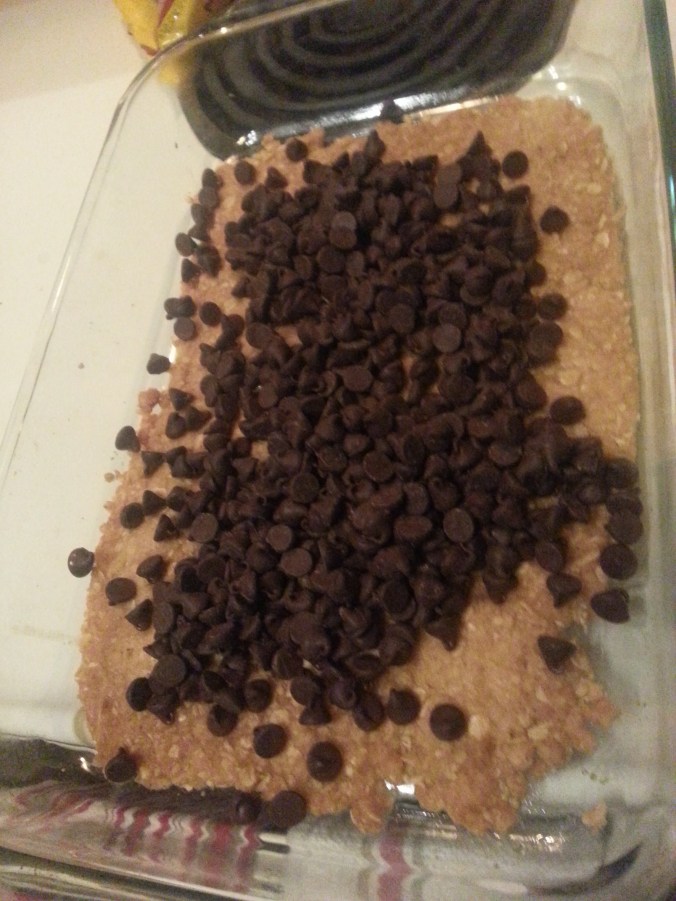 Top the cooked crust with chocolate chips (then caramel and crumbly topping)